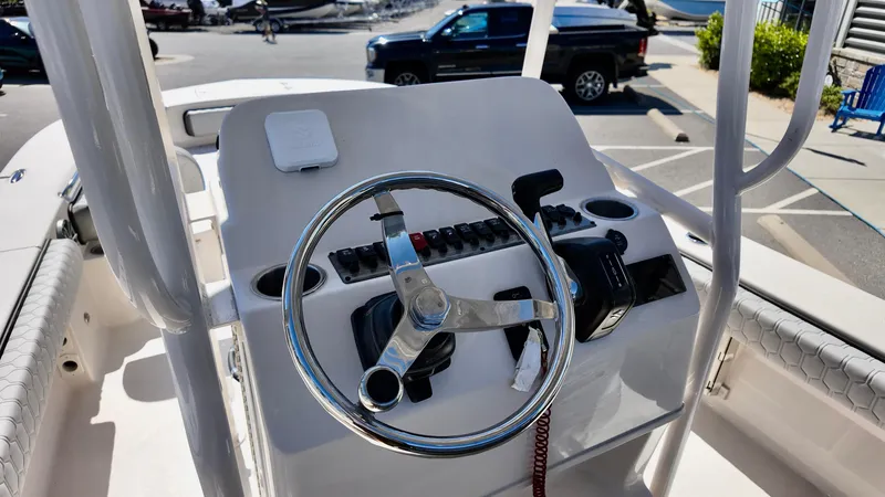 Slide: The Image of 2025 Carolina Skiff 24 Ultra Elite boat console with steering wheel and controls. - 12