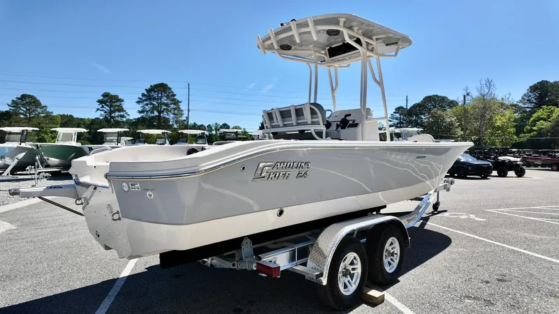 Slide: The Image of 2025 Carolina Skiff 24 Ultra Elite boat on trailer in sunny parking lot. - 2