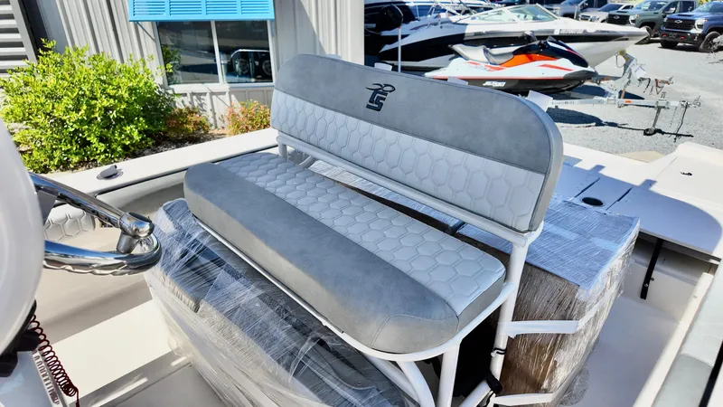 Slide: The Image of 2025 Carolina Skiff 24 Ultra Elite boat seat with gray upholstery in a marina setting. - 9