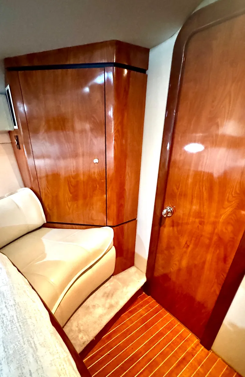 Slide: The Image of Interior of 2005 Fountain 48 Express Cruiser with polished wood finish and beige seating. - 15