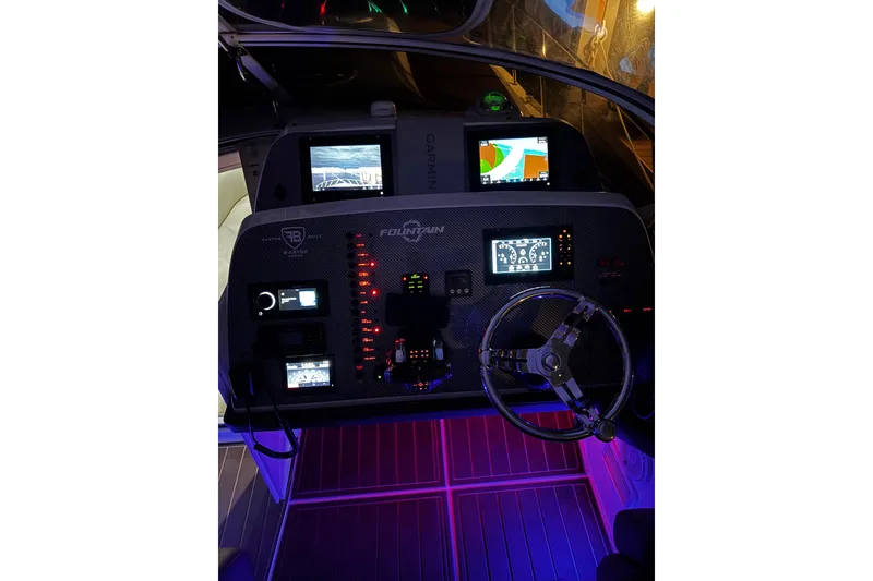 Slide: The Image of 2005 Fountain 48 Express Cruiser dashboard with illuminated controls and navigation screens. - 19