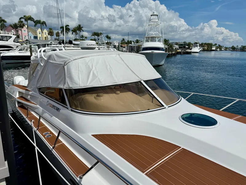 Slide: The Image of 2005 Fountain 48 Express Cruiser docked at marina, clear skies, palm trees in background. - 5