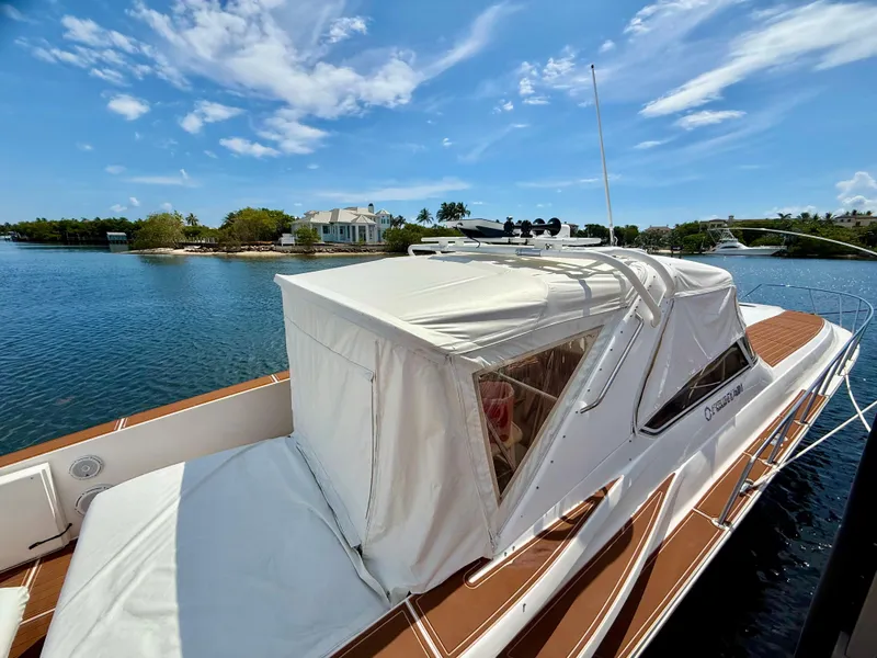 Slide: The Image of 2005 Fountain 48 Express Cruiser docked on a sunny day, with clear blue skies. - 6