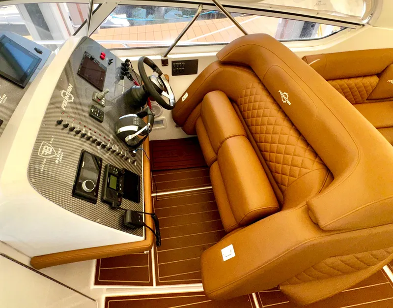Slide: The Image of Luxurious interior of 2005 Fountain 48 Express Cruiser with brown leather seating and modern dashboard. - 8