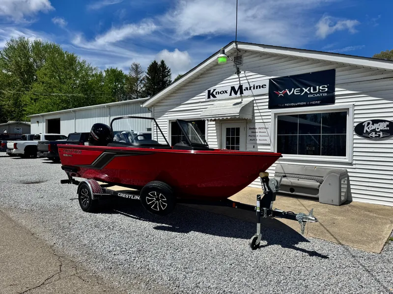 Slide: The Image of 2025 Crestliner 1750 Hawk boat in red, parked outside Knox Marine dealership. - 2
