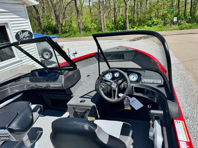 Slide: The Image of 2025 Crestliner 1750 Hawk boat interior with steering wheel and dashboard, parked outdoors. - 6