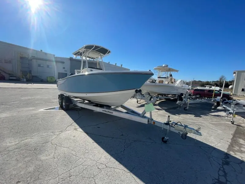Slide: The Image of 2025 Mako 214 Center Console boat on trailer under clear blue sky. - 1