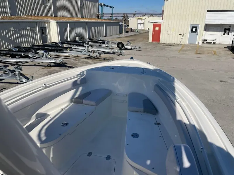 Slide: The Image of 2025 Mako 214 Center Console boat in a storage yard with trailers. - 6