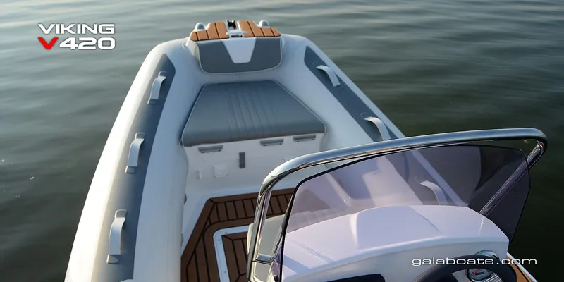 Slide: The Image of Gala Viking V420 boat interior with cushioned seating, wooden accents, and windshield on calm water. - 2