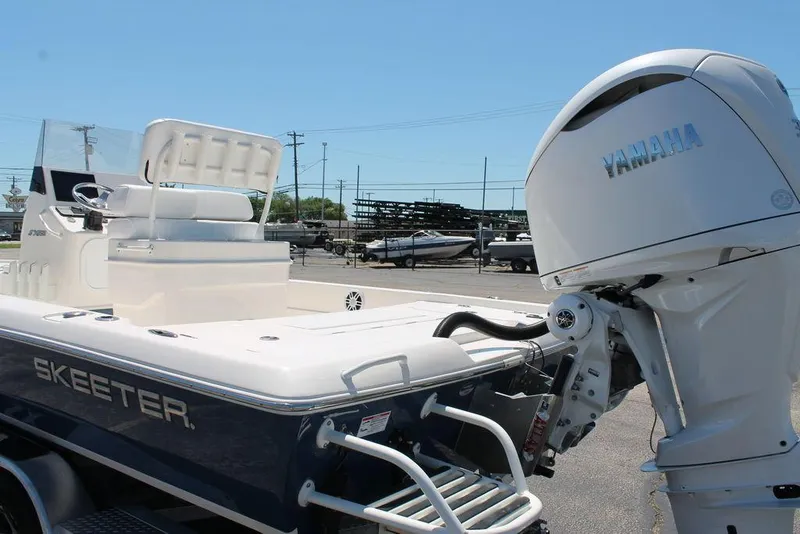 Slide: The Image of 2025 Skeeter SX241 boat with Yamaha outboard motor, parked outdoors. - 10