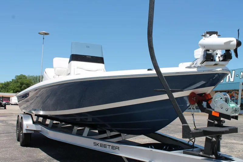 Slide: The Image of 2025 Skeeter SX241 boat on trailer, blue hull, parked outdoors. - 13
