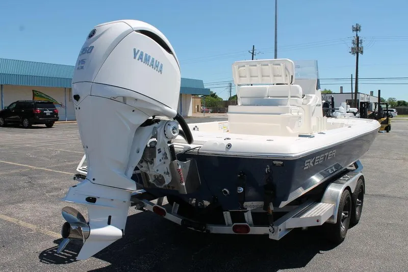 Slide: The Image of 2025 Skeeter SX241 boat with Yamaha engine on trailer in parking lot. - 2