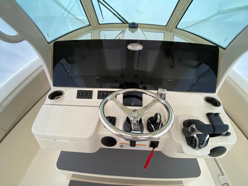 Slide: The Image of Helm of 2026 Scout 357 LXF boat with modern controls and steering wheel. - 2
