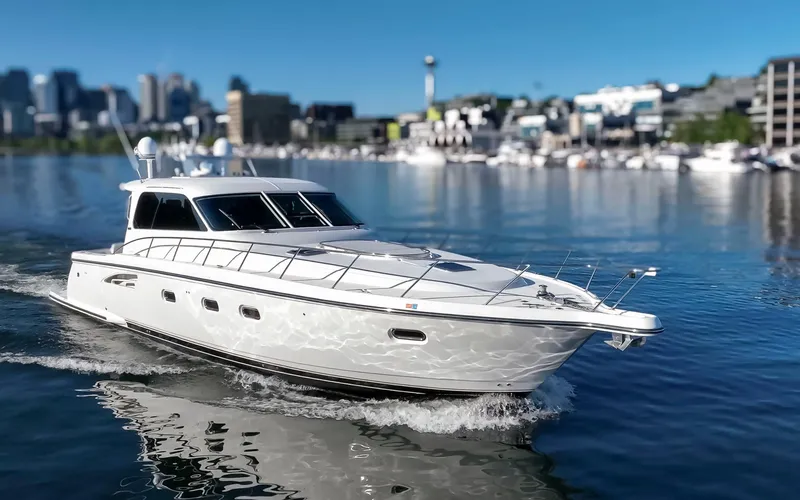 The Image of 2005 Tiara Yachts 5200 Sovran Salon cruising on calm water near a cityscape. - 0