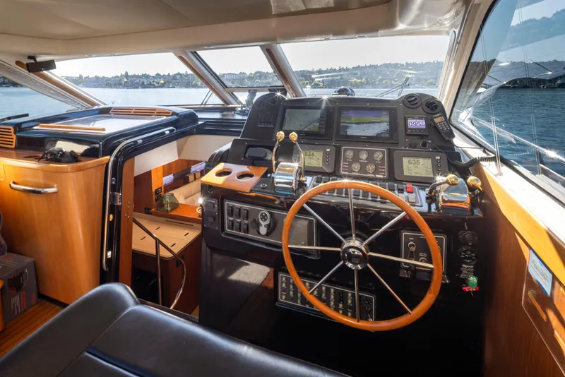 Slide: The Image of 2005 Tiara Yachts 5200 Sovran Salon helm with wooden steering wheel and navigation instruments. - 18