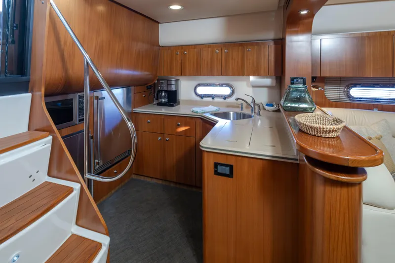Slide: The Image of 2005 Tiara Yachts 5200 Sovran Salon interior with wooden cabinetry and modern kitchen amenities. - 24