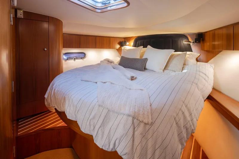 Slide: The Image of Luxurious bedroom in 2005 Tiara Yachts 5200 Sovran Salon with cozy bedding and wood accents. - 30