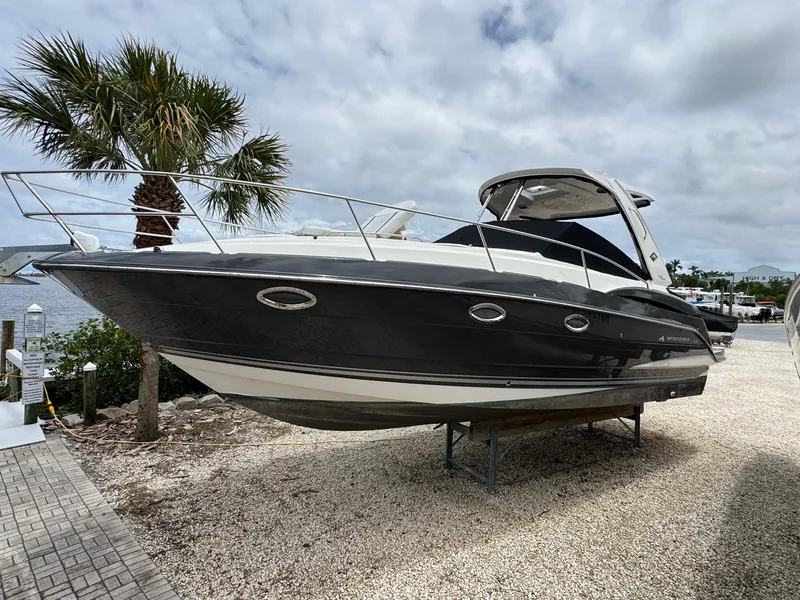 The Image of 2013 Monterey 320 Sport Yacht on display, docked near palm tree, under cloudy sky. - 0