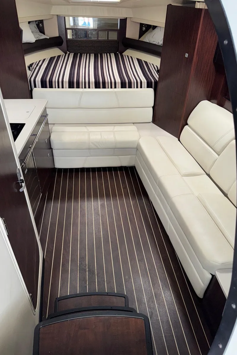 Slide: The Image of Interior of 2013 Monterey 320 Sport Yacht with modern seating and striped bedding. - 32