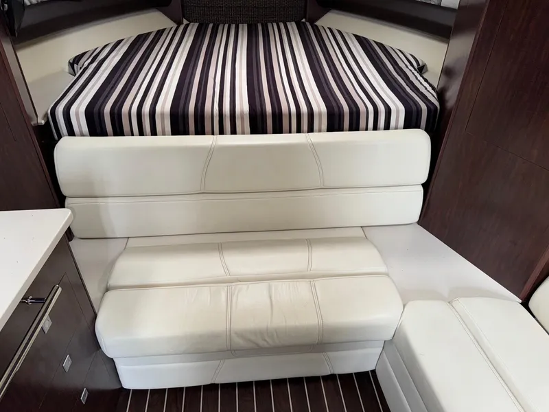 Slide: The Image of Interior of 2013 Monterey 320 Sport Yacht with striped bedding and white seating. - 34