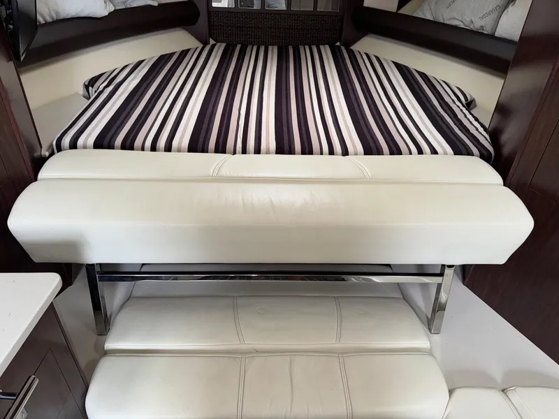 Slide: The Image of Interior of 2013 Monterey 320 Sport Yacht with striped bedding and white seating. - 35