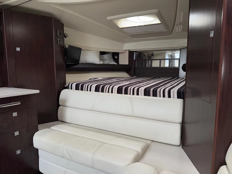 Slide: The Image of Luxurious interior of 2013 Monterey 320 Sport Yacht with striped bedding and white seating. - 36