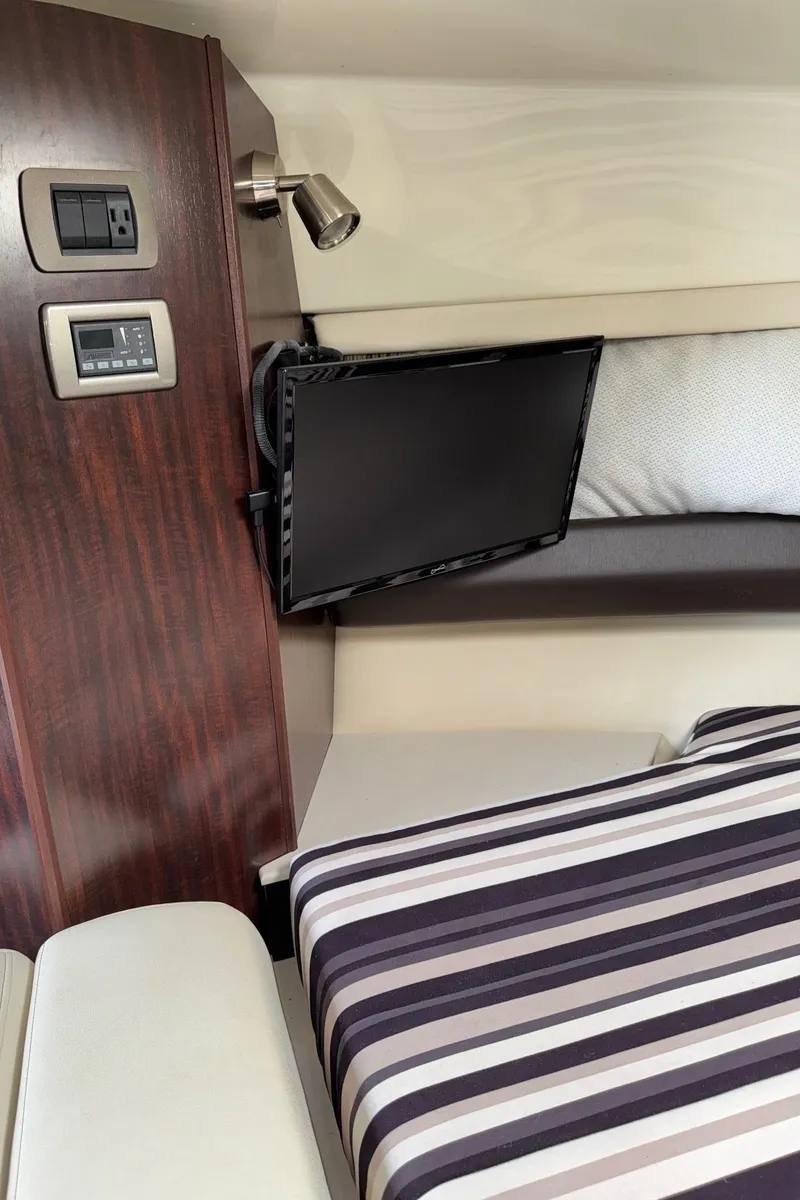 Slide: The Image of Interior of 2013 Monterey 320 Sport Yacht with TV and striped bedding. - 37
