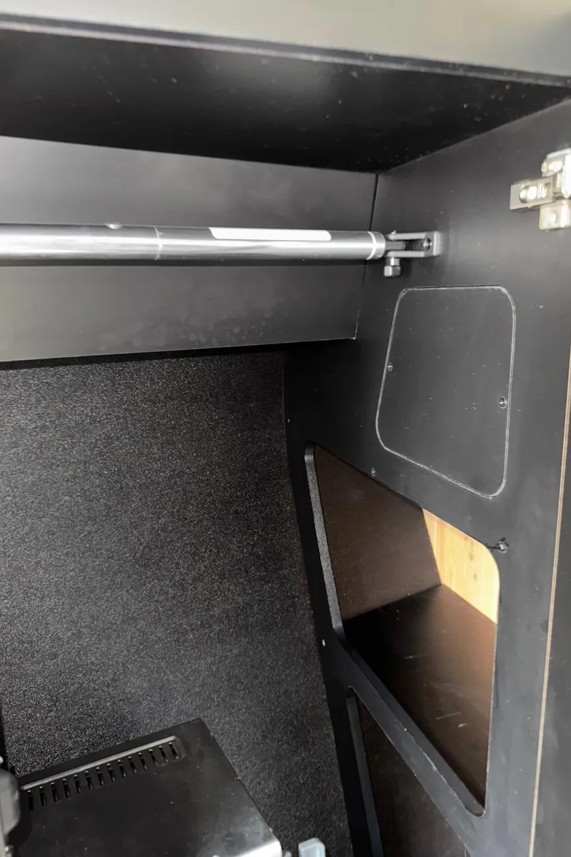 Slide: The Image of Interior storage compartment of a 2013 Monterey 320 Sport Yacht, featuring shelves and a hinge mechanism. - 41