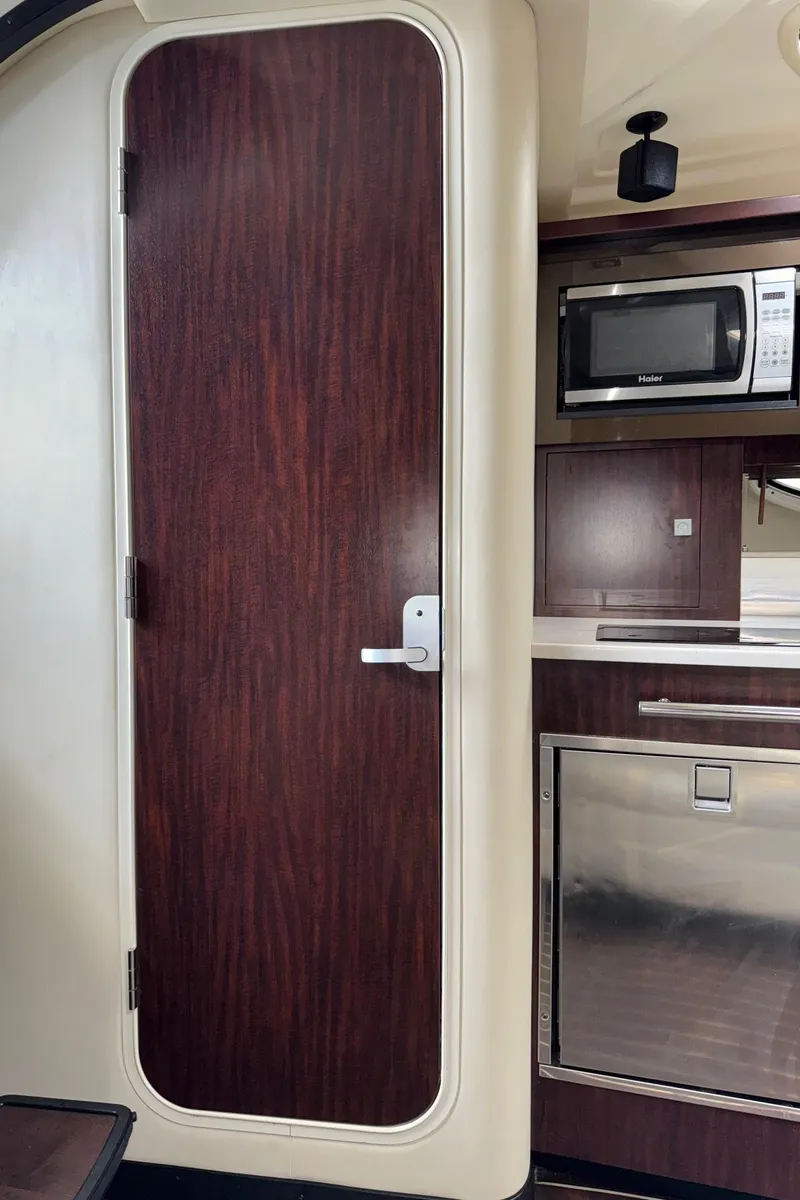 Slide: The Image of Interior of 2013 Monterey 320 Sport Yacht with wood door and modern kitchen appliances. - 48
