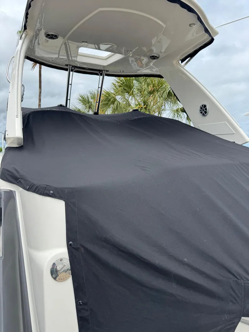 Slide: The Image of 2013 Monterey 320 Sport Yacht covered, docked with palm trees in the background. - 8