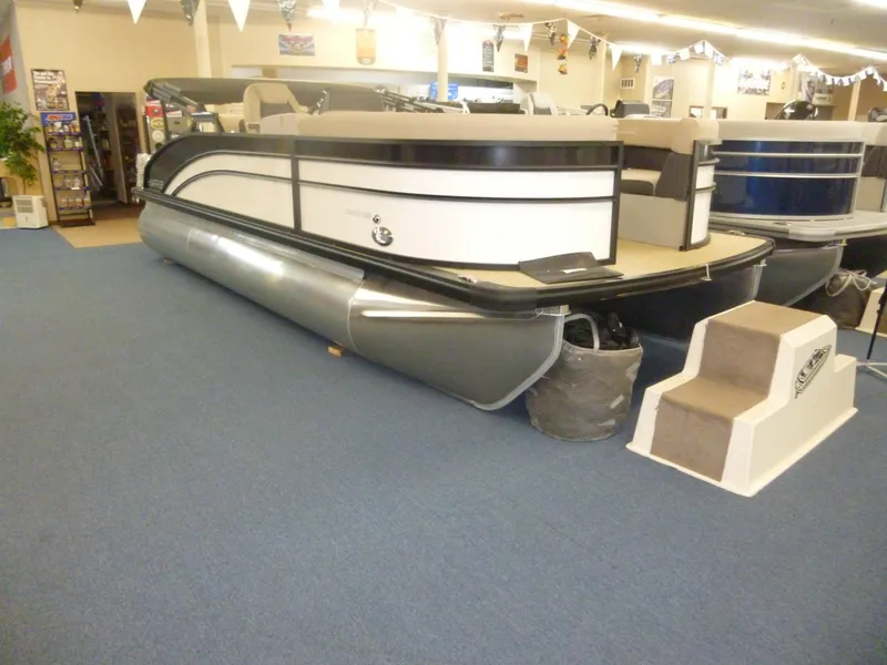 Slide: The Image of 2024 Harris CX210 pontoon boat displayed indoors on blue carpet. - 10