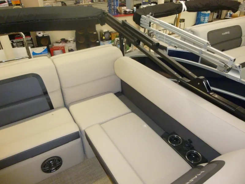 Slide: The Image of 2024 Harris CX210 boat interior with beige seating, cup holders, and speaker system. - 5