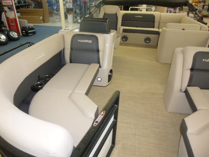 Slide: The Image of 2024 Harris CX210 pontoon boat interior with beige seating and cup holders. - 6