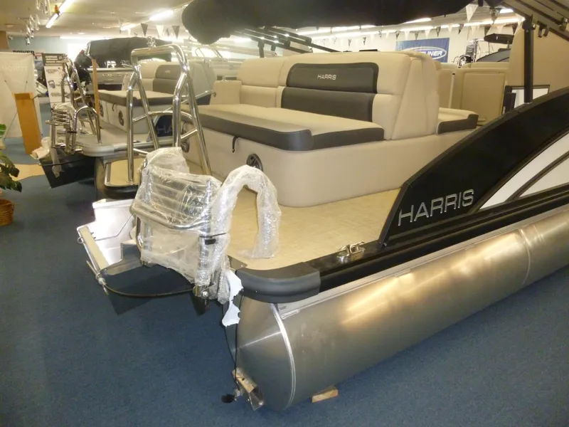 Slide: The Image of 2024 Harris CX210 pontoon boat with plush seating and sleek design in showroom. - 8