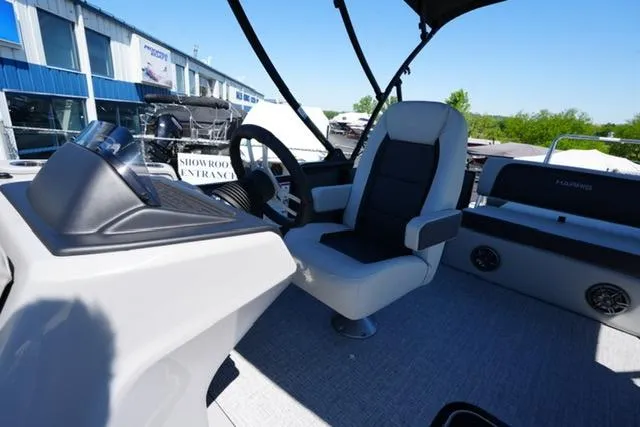 Slide: The Image of 2025 Harris Cruiser 210 boat interior with steering wheel and seating, displayed outdoors. - 11