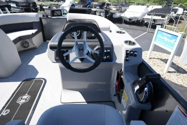 Slide: The Image of 2025 Harris Cruiser 210 boat interior with steering wheel and control panel. - 12