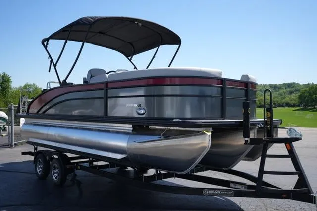 Slide: The Image of 2025 Harris Cruiser 210 pontoon boat on trailer, featuring sleek design and canopy. - 2