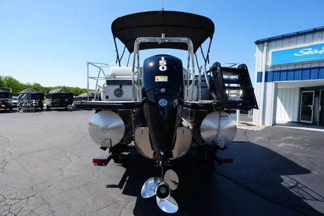 Slide: The Image of 2025 Harris Cruiser 210 boat with 150 HP engine, parked outdoors near a building. - 4