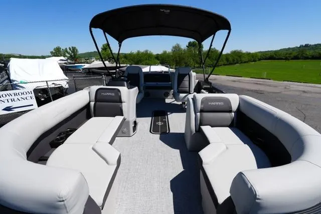 Slide: The Image of 2025 Harris Cruiser 210 pontoon boat with spacious seating and canopy, docked outdoors. - 6