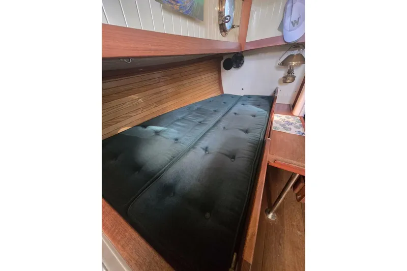 Slide: The Image of Interior of 1994 Bristol Channel Cutter Sam L Morse BCC 28, featuring a cozy cabin berth. - 21