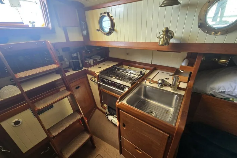 Slide: The Image of 1994 Bristol Channel Cutter BCC 28 interior with compact kitchen and wooden cabinetry. - 24