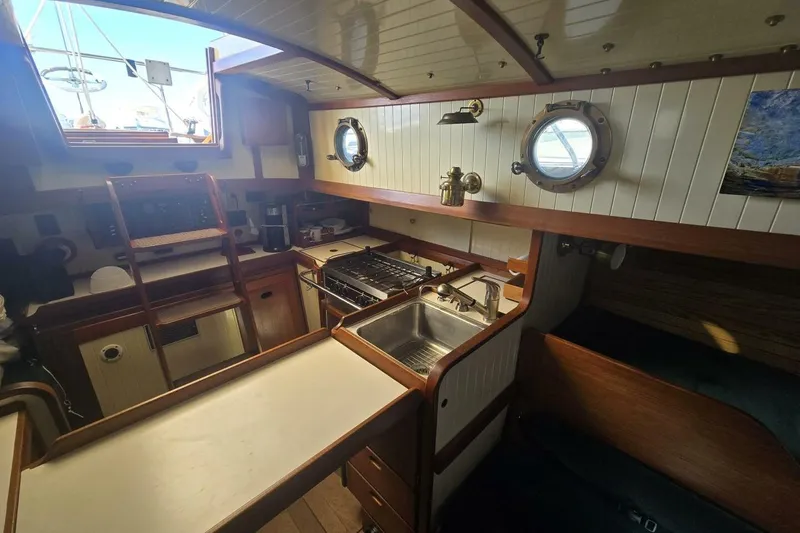 Slide: The Image of Interior of 1994 Bristol Channel Cutter Sam L Morse BCC 28, featuring a cozy galley kitchen. - 25