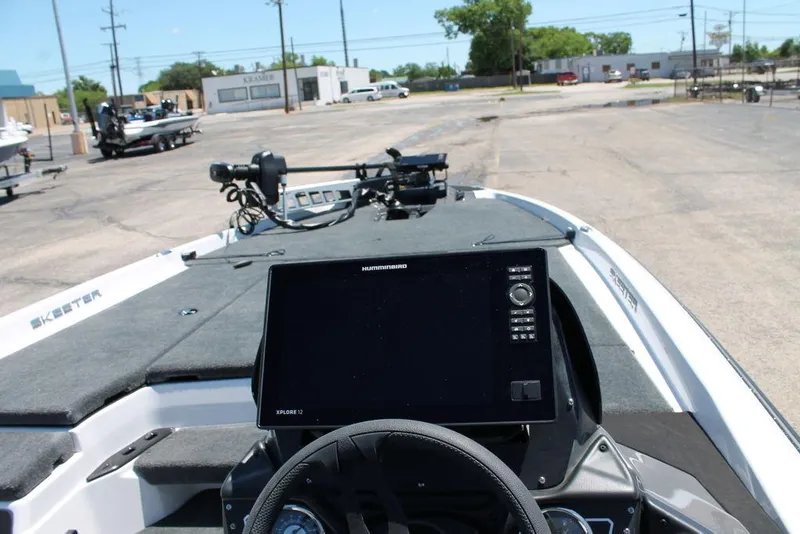 Slide: The Image of 2025 Skeeter ZXR21 boat dashboard with advanced navigation system in a parking lot. - 4