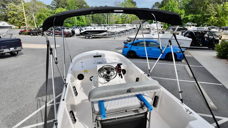 Slide: The Image of 2025 Carolina Skiff 178 JLS CC boat in parking lot, surrounded by cars and trees. - 10