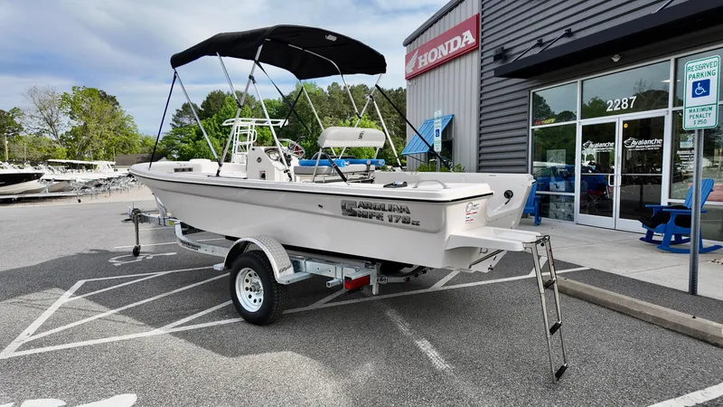 Slide: The Image of 2025 Carolina Skiff 178 JLS CC boat on trailer outside dealership. - 13