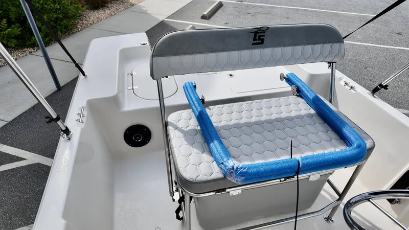 Slide: The Image of 2025 Carolina Skiff 178 JLS CC boat interior with cushioned seating and blue armrests. - 4