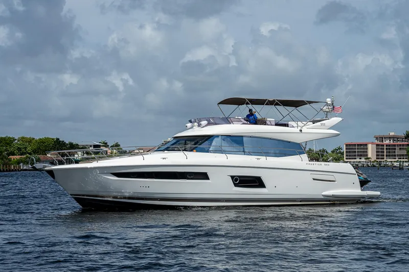 Slide: The Image of Luxury 2014 Prestige 550 yacht cruising on a calm waterway under cloudy skies. - 10