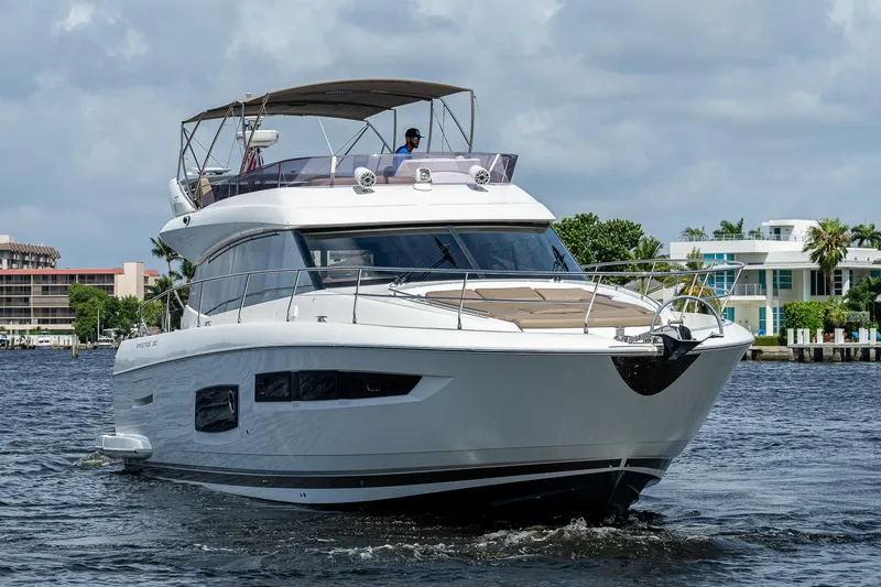 Slide: The Image of Luxury 2014 Prestige 550 yacht cruising on a sunny day, featuring sleek design and modern amenities. - 13