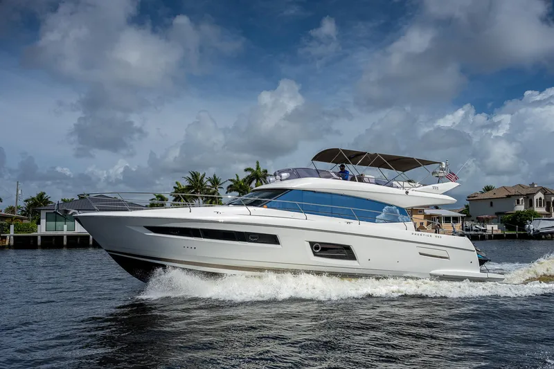 Slide: The Image of Luxury 2014 Prestige 550 yacht cruising on a scenic waterway under a cloudy sky. - 24