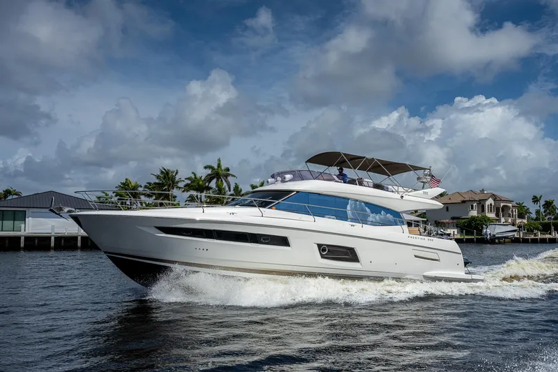 Slide: The Image of 2014 Prestige 550 yacht cruising on a sunny day near waterfront homes. - 25